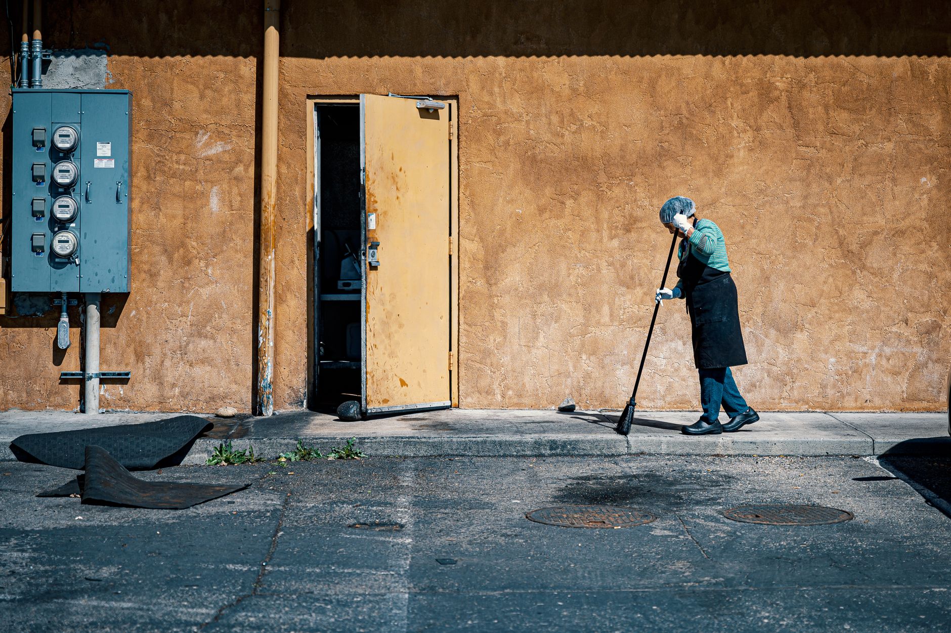 Worker cleaning dust accumulation from equipment surfaces