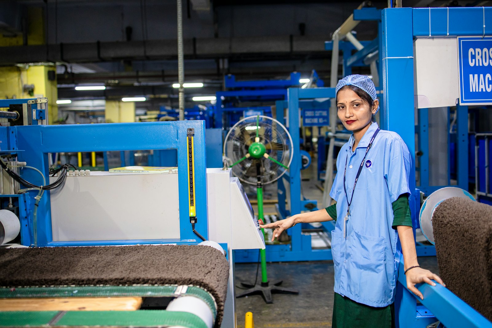 Factory worker operating a production machine on the floor