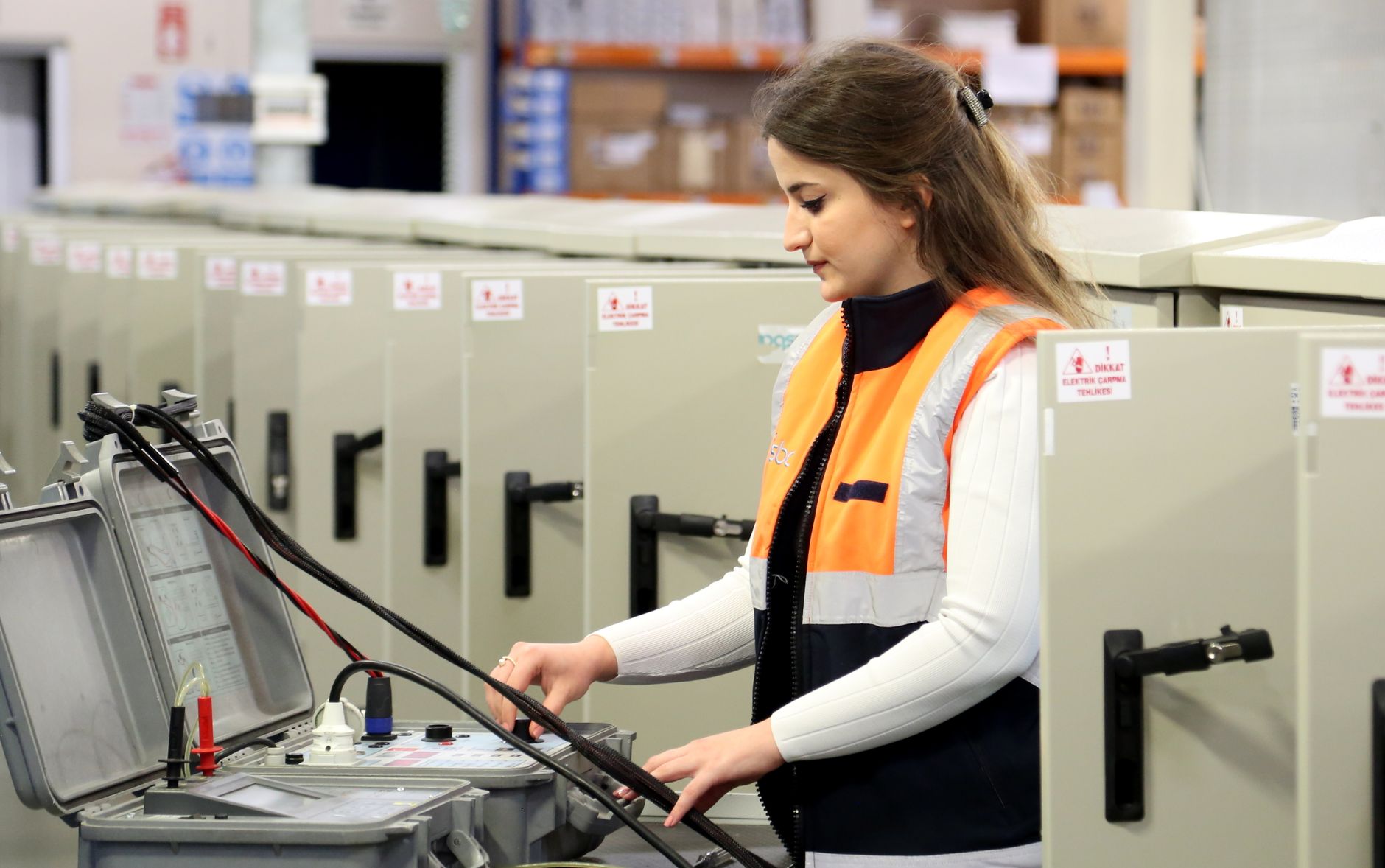 Technician wiring a safety-rated PLC control panel