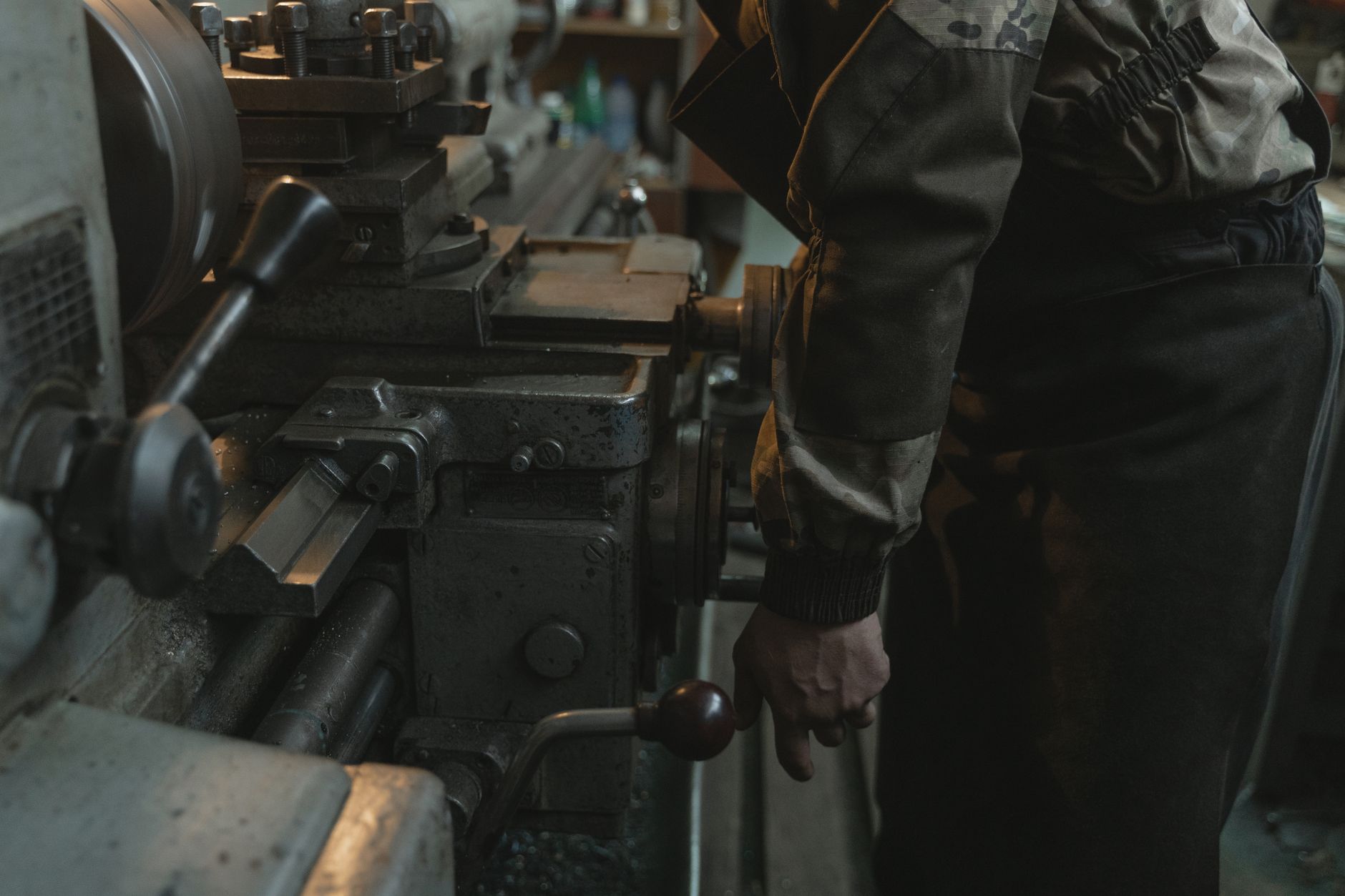 Machinist operating a manual lathe