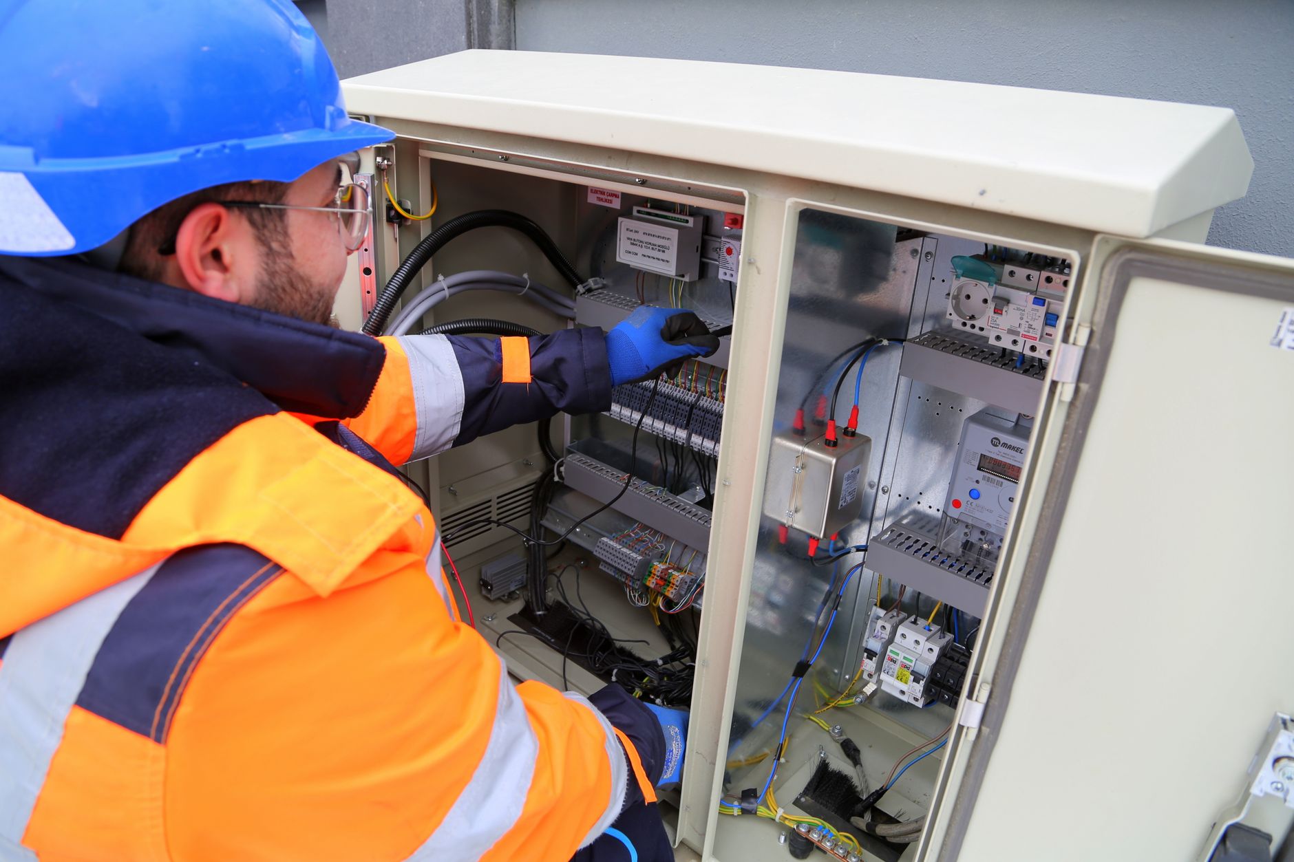 Technician inspecting an industrial control cabinet