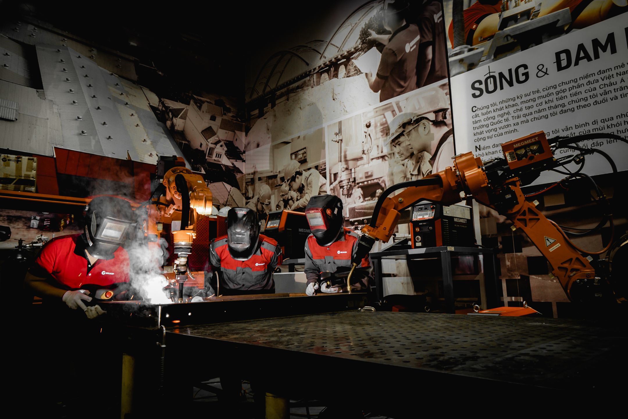 Industrial robots welding with operators working alongside