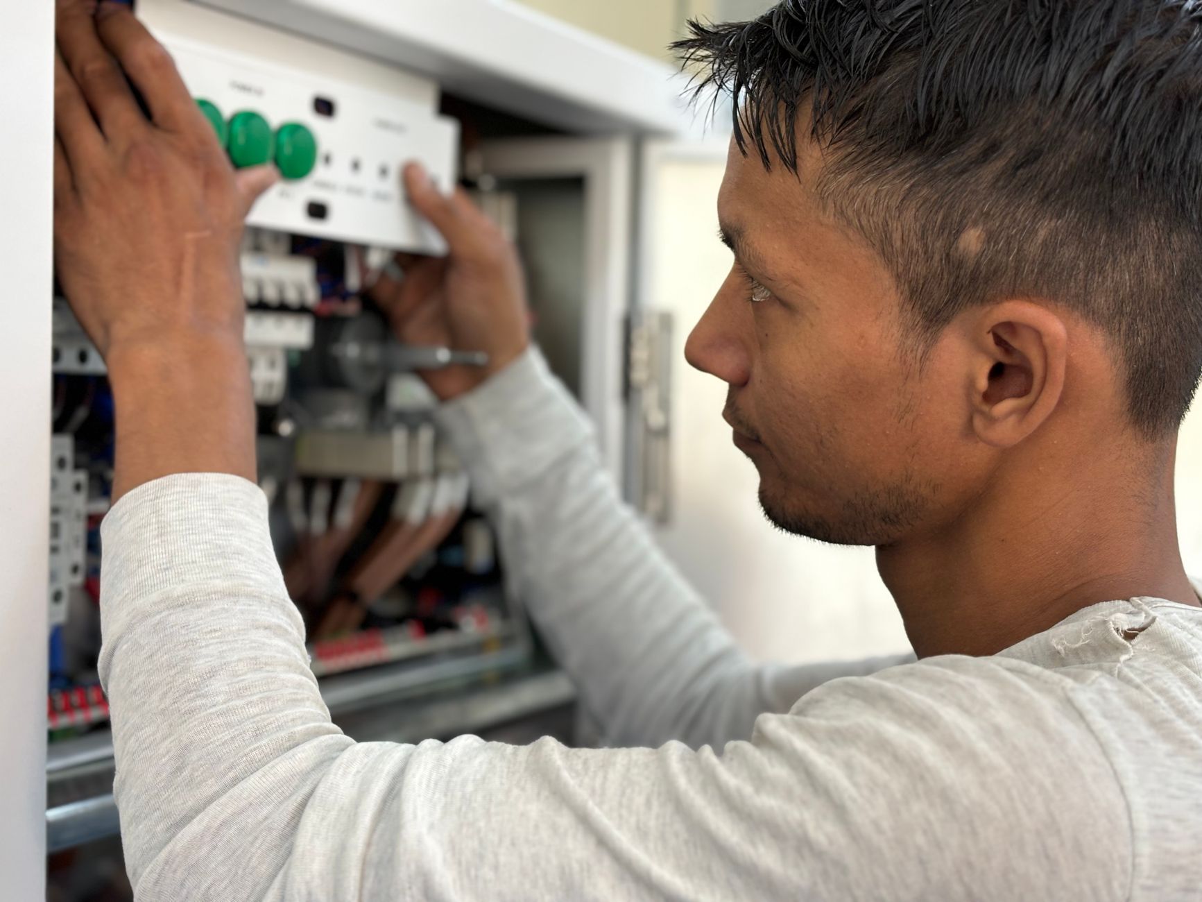 Technician troubleshooting encoder wiring on a machine