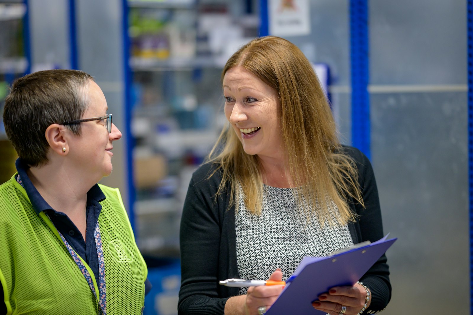 Supervisor mentoring a new employee in a warehouse setting