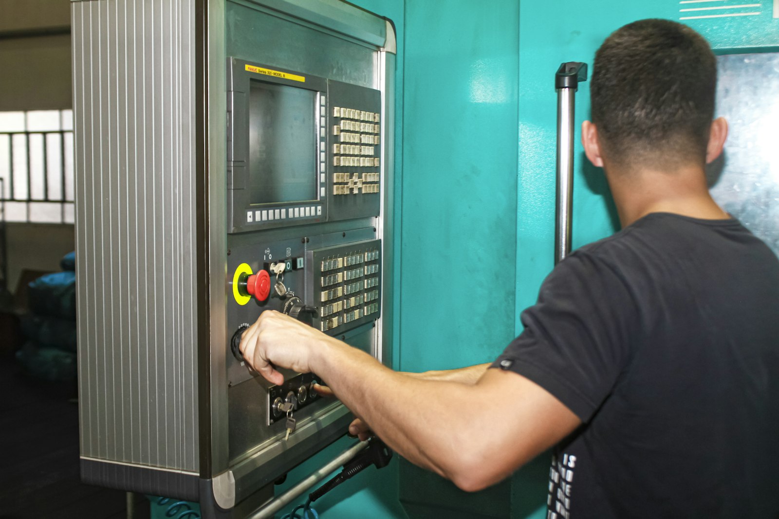Trainee operating a CNC machine control panel