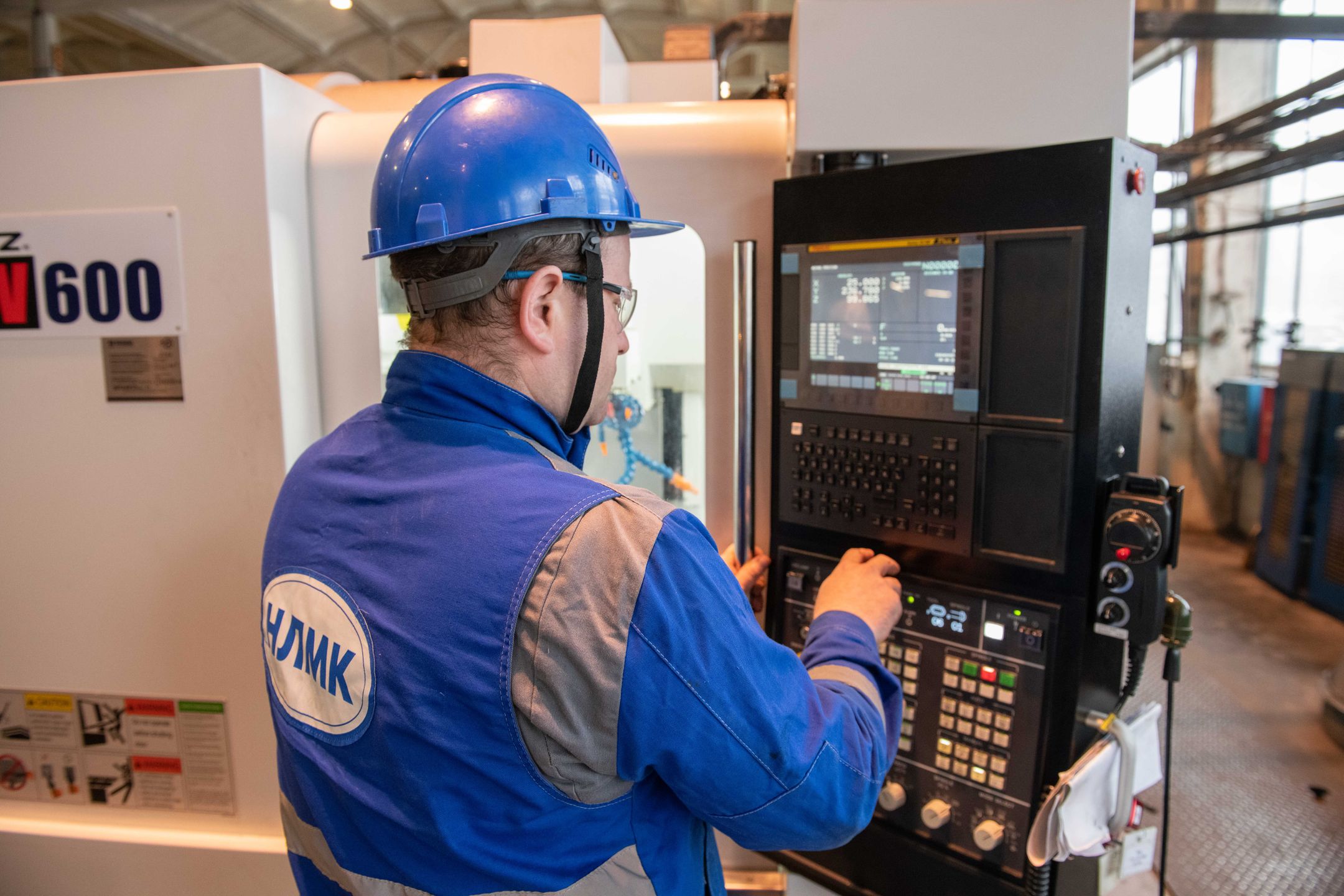 Factory worker operating a CNC machine