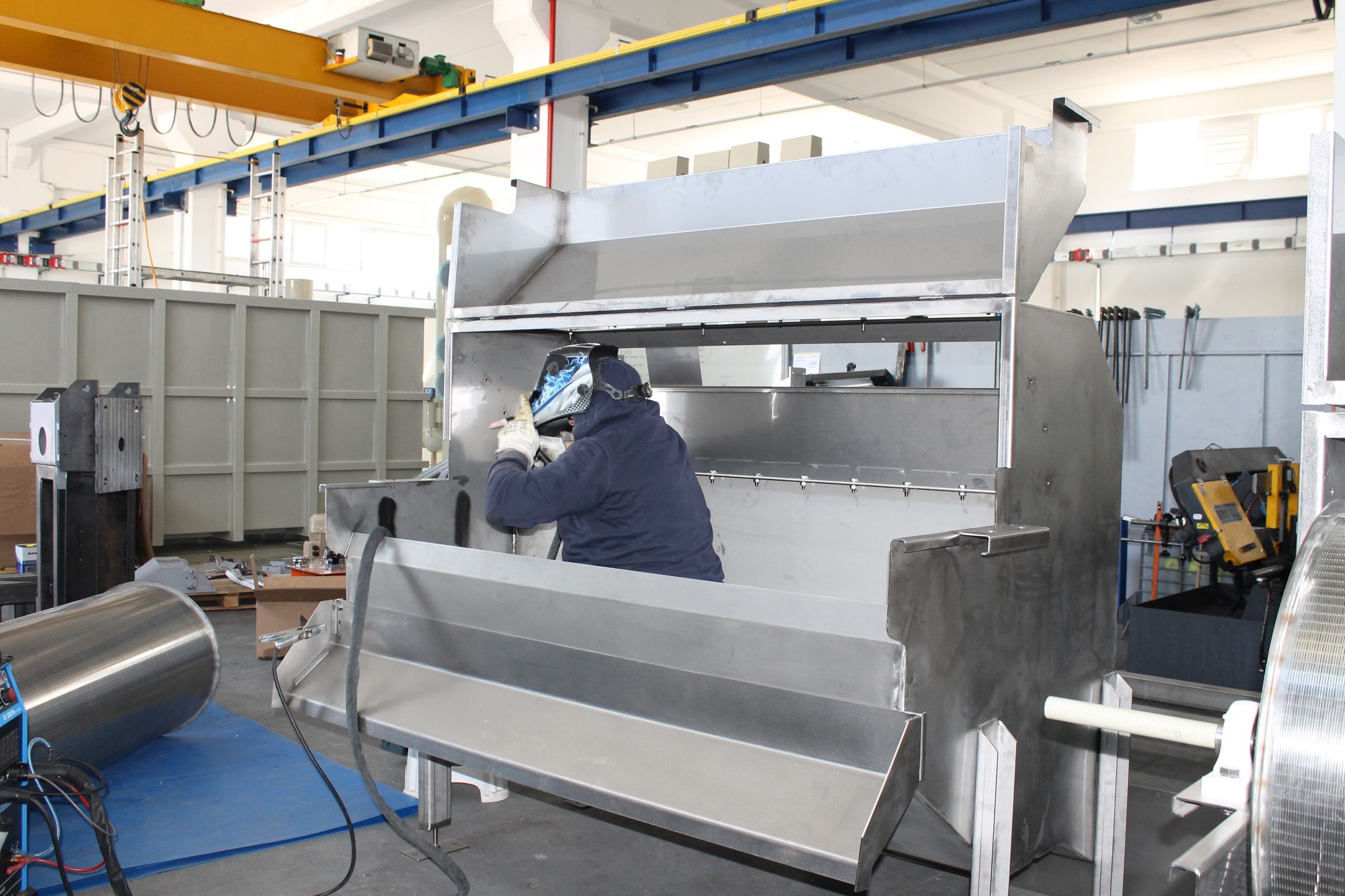 Worker welding metal components in an industrial factory