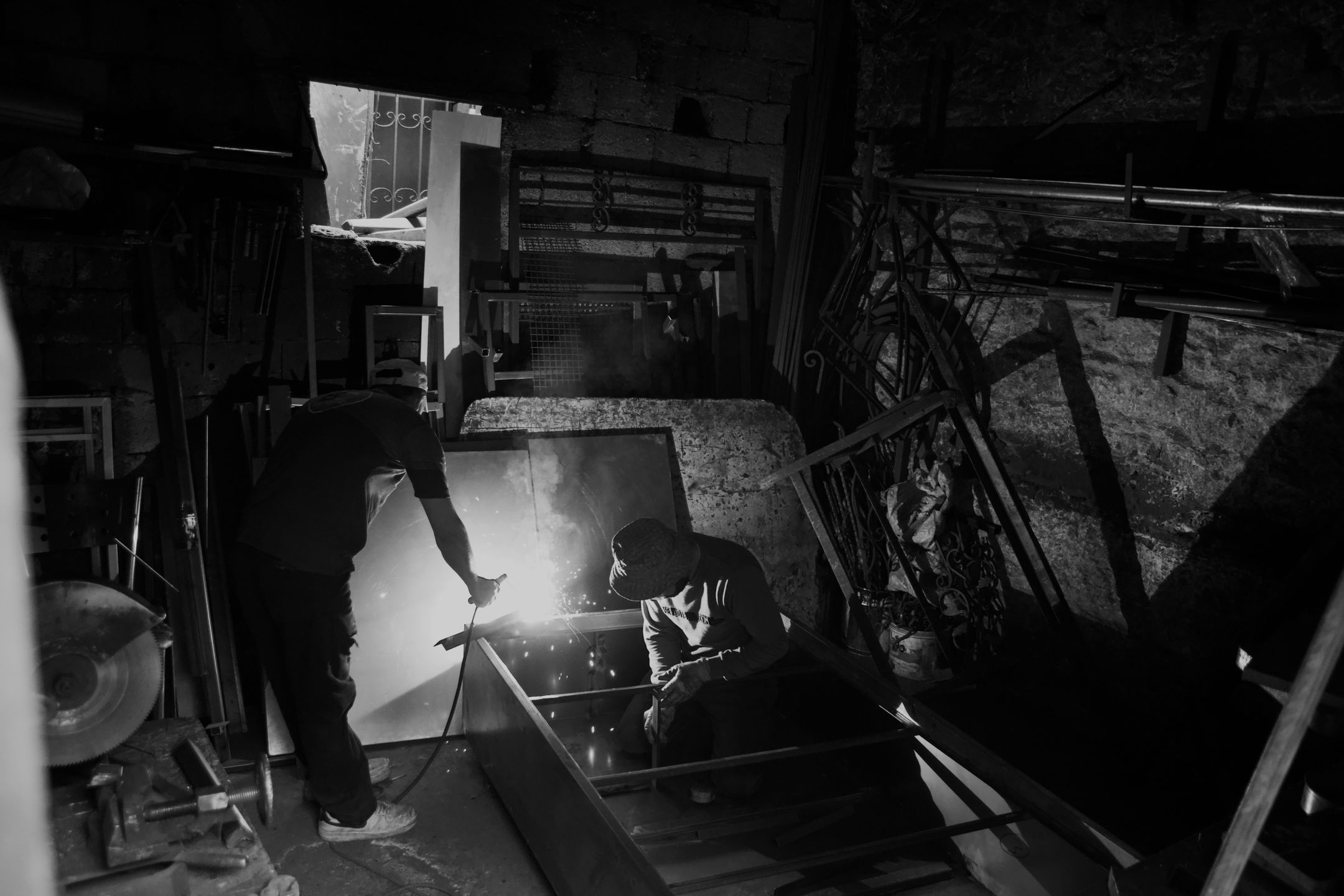 Two welders working together in a workshop