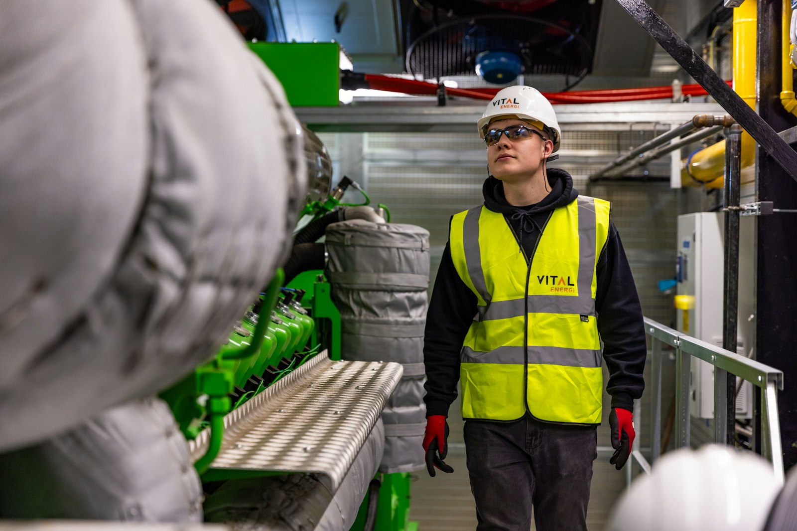 Young worker in a safety vest at an industrial facility